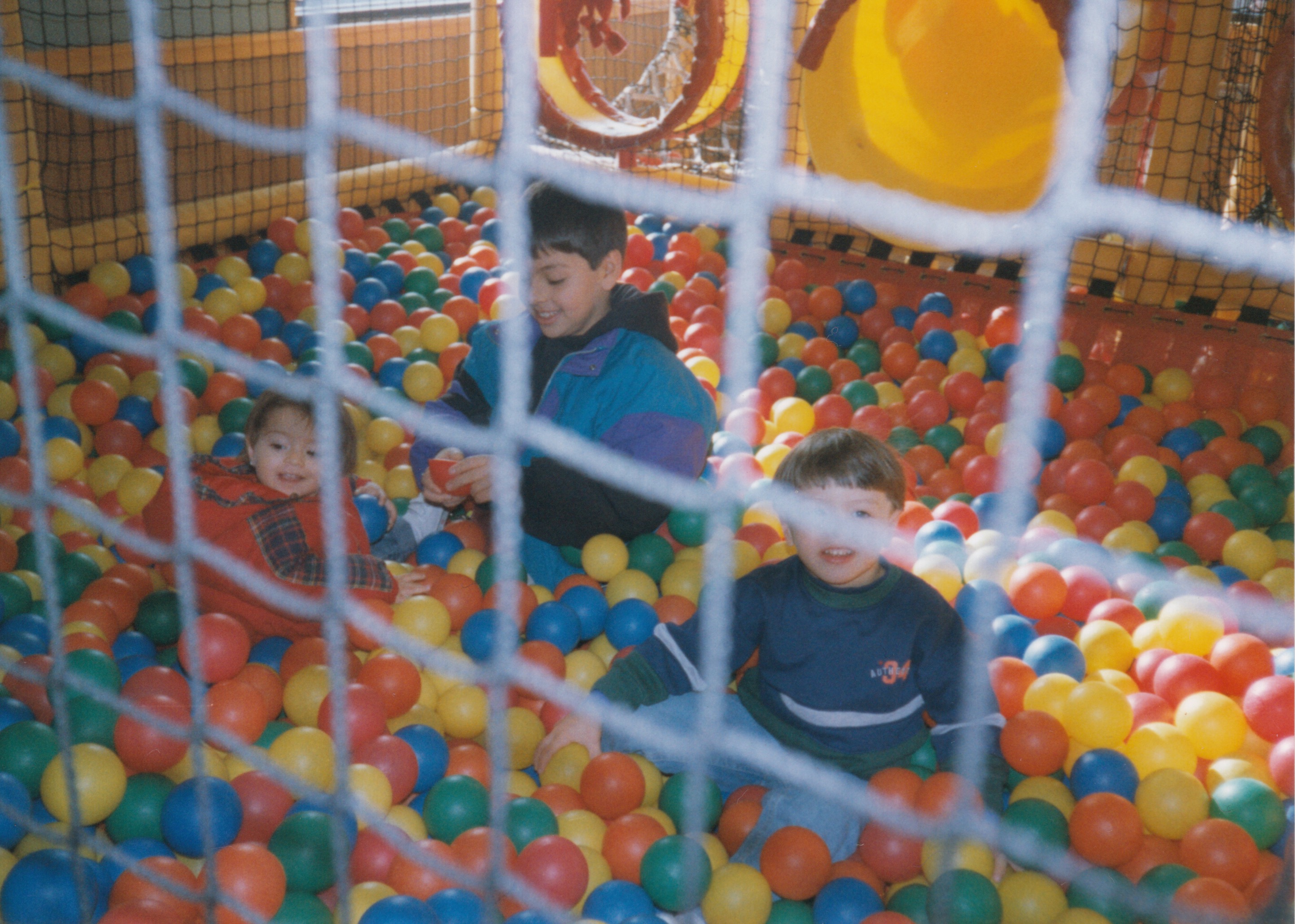 a picture of kristina, carlos, and julio in a ball pit